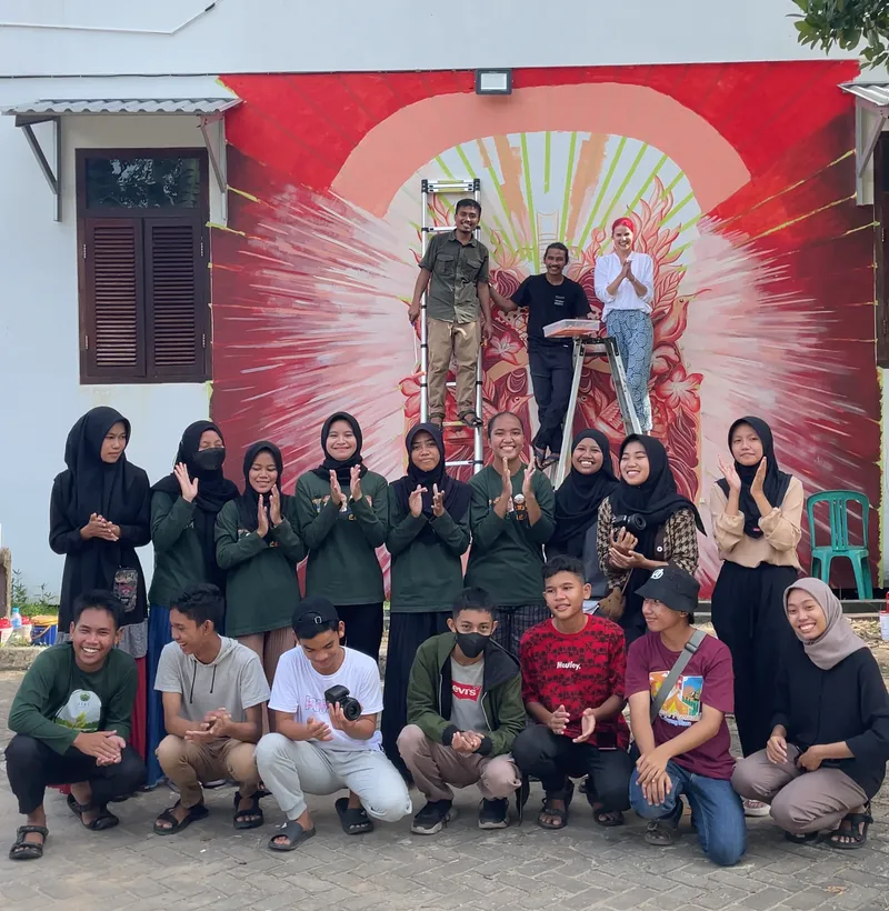 Community gathered in front of the mural Ekaterina painted in Borneo